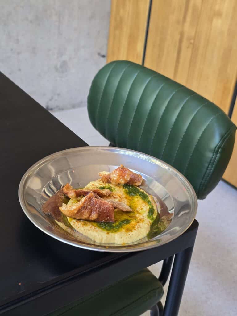 Crocante de pernil sobre hummus