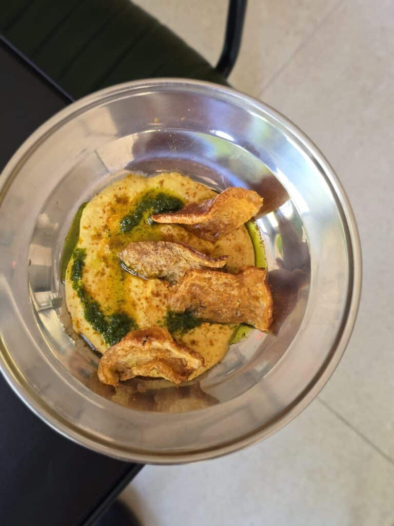 Crocante de pernil sobre hummus